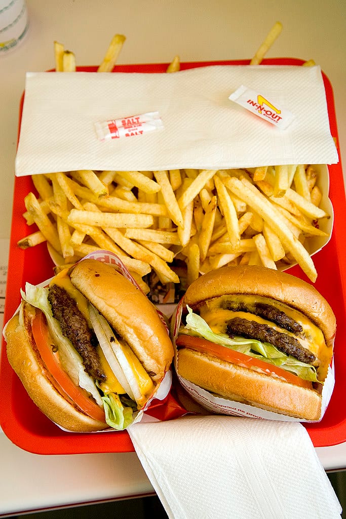 An In-N-Out tray with two burgers, fries, and a salt packet on the napkin
